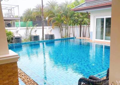 Private outdoor swimming pool with surrounding patio and garden