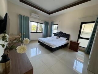 Spacious bedroom with large windows and modern furnishings