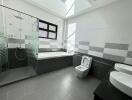 Modern bathroom with bathtub, shower, toilet, and double sinks