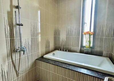 Modern bathroom with bathtub and overhead shower