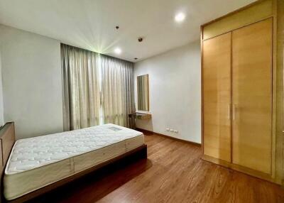 Spacious bedroom with wooden floor and built-in wardrobe