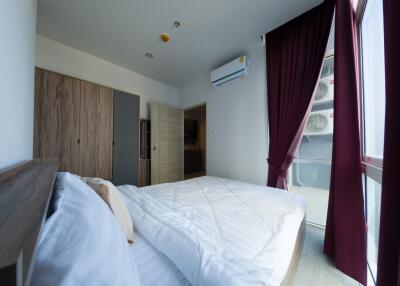 Modern bedroom with wooden wardrobe and large windows