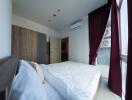 Modern bedroom with wooden wardrobe and large windows