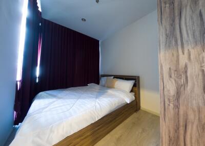 Bedroom with bed and burgundy curtains