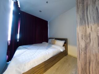 Bedroom with bed and burgundy curtains