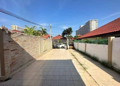 Paved outdoor area with brick wall and parked car