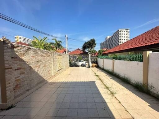 Paved outdoor area with brick wall and parked car