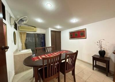 Dining room with wooden table and chairs, decorative items, wall-mounted fan, and air conditioning