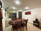 Dining room with wooden table and chairs, decorative items, wall-mounted fan, and air conditioning