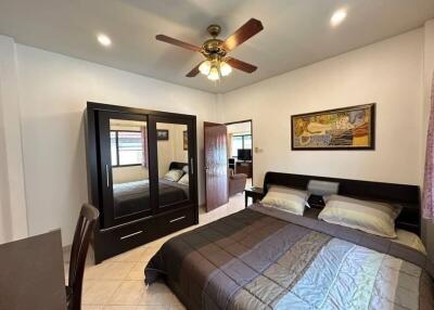 Spacious bedroom with large bed, wardrobe, and ceiling fan