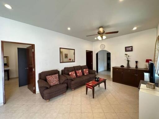 Spacious living room with seating and ceiling fan