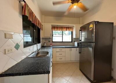 Modern kitchen with black granite countertops and large refrigerator