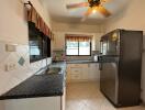 Modern kitchen with black granite countertops and large refrigerator