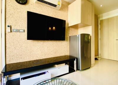 Modern living room with TV, air conditioning, and refrigerator