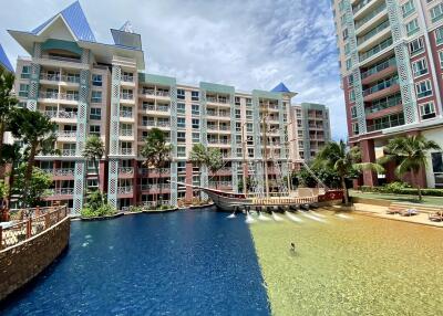 Exterior view of a condominium with swimming pools and a decorative ship