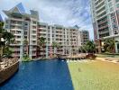 Exterior view of a condominium with swimming pools and a decorative ship