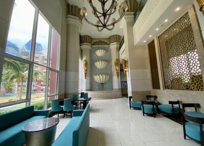 Modern lobby with decorative walls, blue seating, and large windows