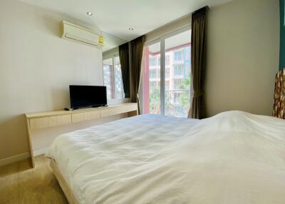 Bedroom with a large bed, television, and window view