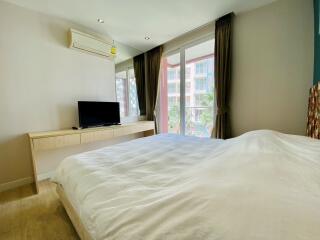 Bedroom with a large bed, television, and window view