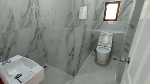 Modern bathroom with marble tiles and toilet