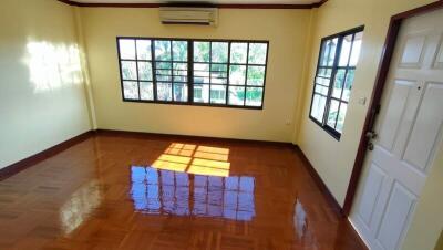 Bright empty room with wooden floor and large windows