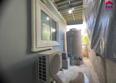 Outdoor utility area with water tank and air conditioning unit