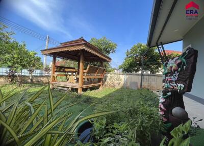 Beautifully landscaped yard with a wooden gazebo and lush greenery