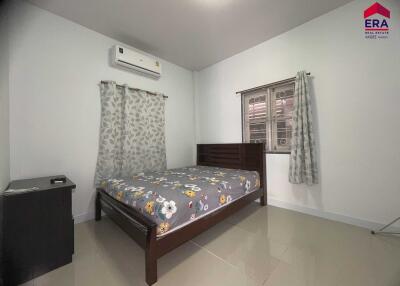 Bedroom with bed, air conditioner, curtains, and nightstand