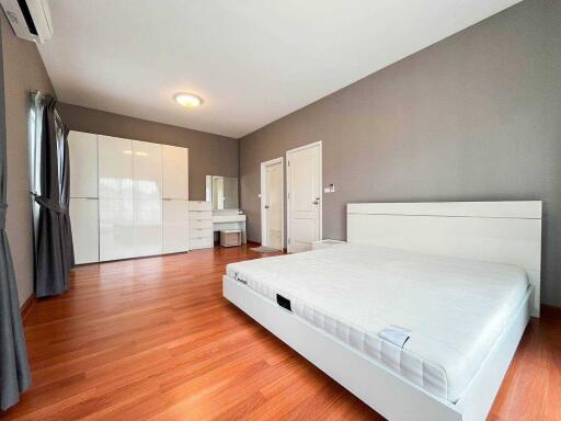 Spacious bedroom with large bed, ample storage, and a vanity desk