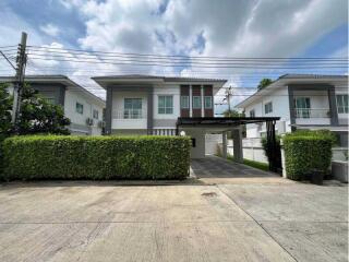 Front view of a modern two-story house with carport