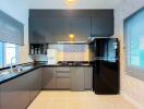 Modern kitchen with grey cabinetry and black appliances