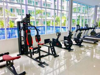 Modern fitness center with equipment overlooking a pool