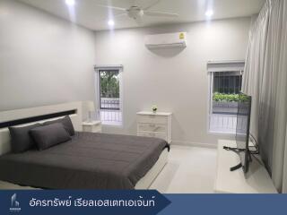 Modern and clean bedroom with a large bed, windows, and a flat-screen TV