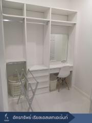 Walk-in closet with built-in shelving and vanity area