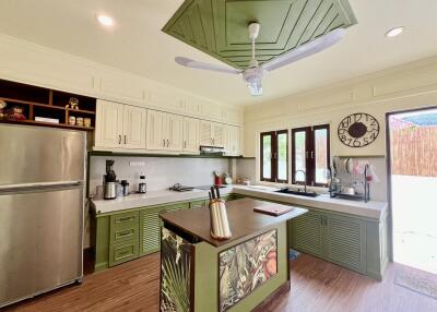 Modern kitchen with island and green cabinetry