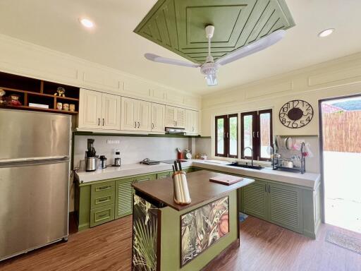 Modern kitchen with island and green cabinetry