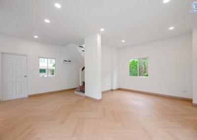 Spacious well-lit main living area with wooden flooring and large windows