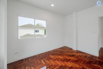 Empty bedroom with wooden floor and window