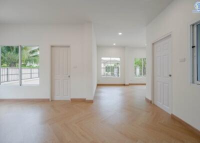 Spacious living area with large windows and wooden flooring