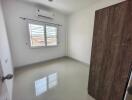 Empty bedroom with window and wooden door