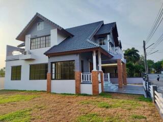 Two-story house with a gable roof and a well-maintained lawn