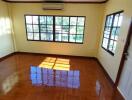 a bright and inviting living space with large windows and polished wooden floors