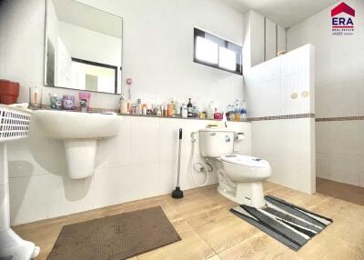 Well-lit bathroom with sink, toilet, window, and tiled floor