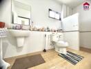 Well-lit bathroom with sink, toilet, window, and tiled floor