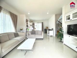 Modern and spacious living room with neutral tones, large windows, and contemporary furniture.