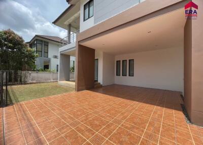 View of the exterior of a residential property with a tiled patio area and covered space