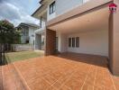 View of the exterior of a residential property with a tiled patio area and covered space