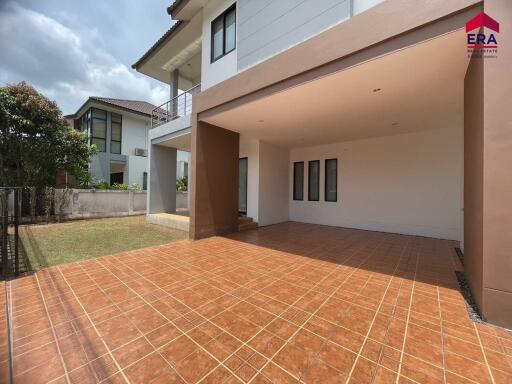 View of the exterior of a residential property with a tiled patio area and covered space