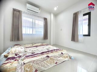 Bright bedroom with windows, air conditioning, and set up mattress