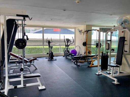 Fitness center with various gym equipment and windows